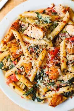 a white plate topped with pasta and chicken