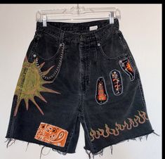 a pair of black jean shorts with patches on them