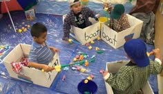 children playing with boats made out of cardboard