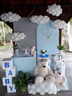 there is a baby shower with balloons and teddy bears on the table in front of it