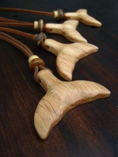 three pieces of wood that are on a wooden table and one has a cord attached to it