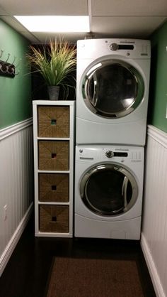 a washer and dryer in a small room with green paint on the walls