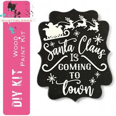 a black and white sign with santa claus is coming to town on it's side