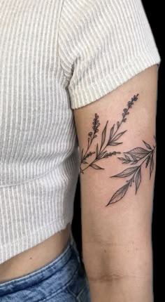 a woman's arm with a tattoo on it that has flowers and leaves growing out of it