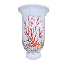 a white vase with red corals and shells painted on the side, against a white background