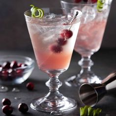 two glasses filled with cranberry gin and garnished with cherries on the rim