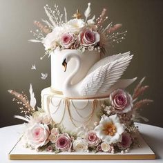 a wedding cake decorated with flowers and a swan