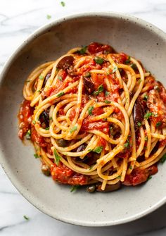 a white bowl filled with spaghetti and sauce