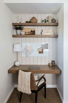 a small home office with wooden shelves and white walls