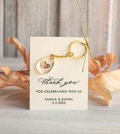 a card with a gold keychain attached to it that says thank you for celebrating with us