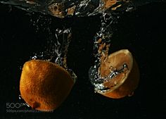 an orange is being dropped into the water