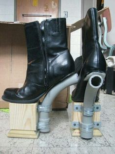 a pair of black boots sitting on top of wooden blocks