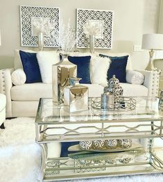 a living room filled with white furniture and blue pillows