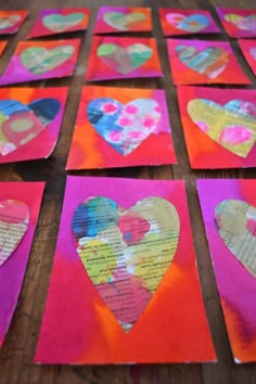 several pieces of paper with hearts cut out of them on top of a wooden table