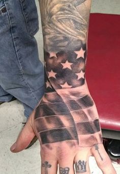 a hand with an american flag tattoo on it