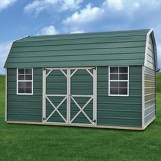 a large green shed sitting on top of a lush green field in front of a blue sky