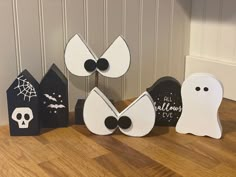 halloween decorations made to look like ghost faces and houses on the floor in front of a door