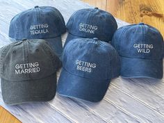 five hats with the words getting married and getting drunk on them sitting on a table