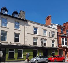 two cars are parked on the street in front of some buildings