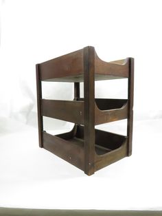 a wooden shelf with two open shelves on it's sides, against a white background