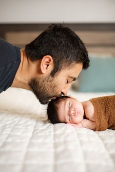 a man kissing his baby on the nose