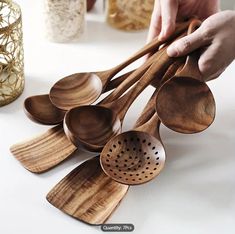 wooden utensils with holes in them are being held by someone's hand