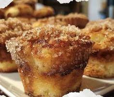 some sugary muffins sitting on top of a white plate with crumbs