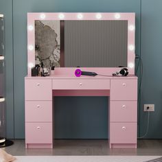 a pink vanity table with lights on it