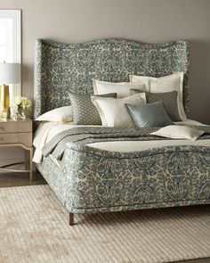 a bed with blue and white comforter in a bedroom next to a nightstand table