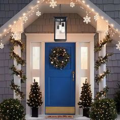 a blue front door decorated with christmas lights