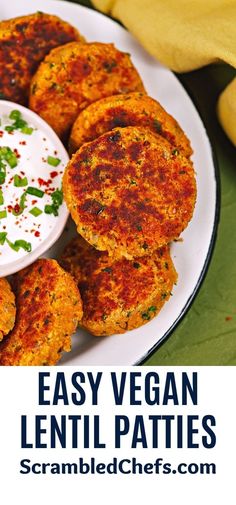 a white plate topped with crab cakes next to a bowl of ranch dressing