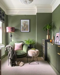 a living room with green walls and furniture, including a small chair in the corner