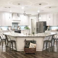 a large kitchen with white cabinets and an island