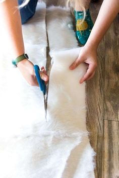 a person cutting fur with scissors on the floor