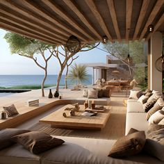 an outdoor living area with couches, tables and water in the backgroud