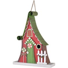 a red and green birdhouse with candy canes on the roof