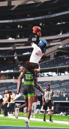 two people jumping in the air at a football game