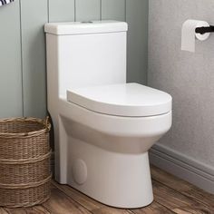 a white toilet sitting in a bathroom next to a basket