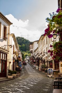 a cobblestone street lined with shops and restaurants