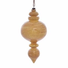 a wooden ornament hanging from a rope on a white background with clippings