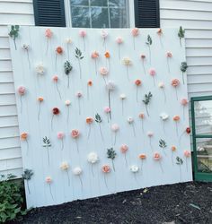 flowers are arranged on the side of a white wall