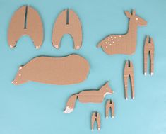 several pieces of cardboard cut out of animals on a blue background, including deers and giraffes