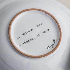 a close up of a plate with writing on the side and an inscription on it