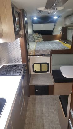 the interior of a camper with an oven and sink