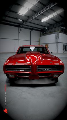 a red car parked in a garage with a heart on the hood