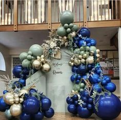 blue and gold balloons are arranged in the shape of a wreath on top of a table