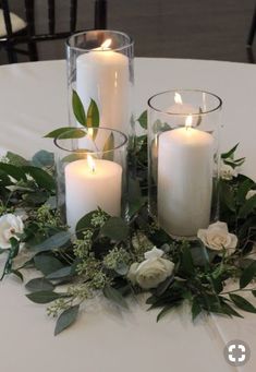 some candles are sitting on a table with flowers