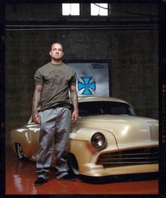 a man standing next to an old car