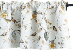 a curtain with birds on it hanging from the side of a window sill in front of a white background