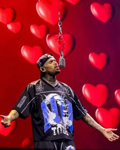 a man with his hands out in front of a red heart background, holding a pair of scissors